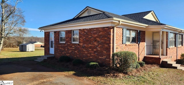 view of side of property featuring a shed and a yard