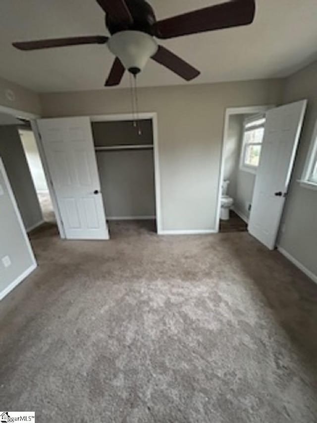 unfurnished bedroom featuring ceiling fan, carpet, ensuite bathroom, and a closet