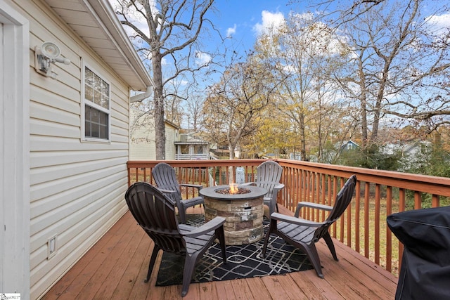 deck with an outdoor fire pit and a grill