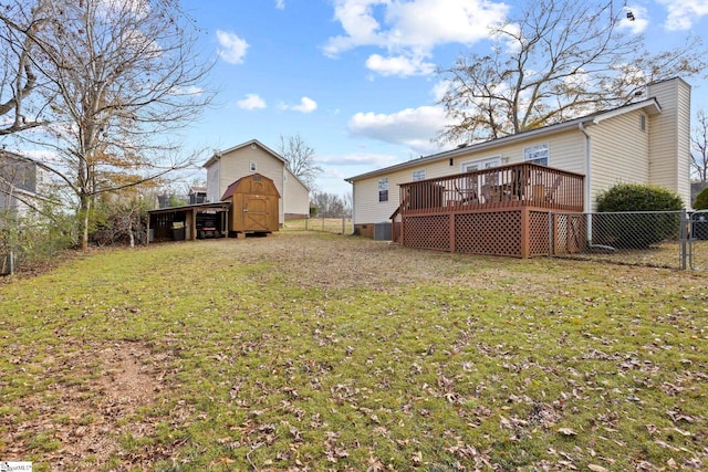 view of yard with central AC unit, a deck, and a storage unit