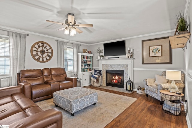 living room with hardwood / wood-style floors, ceiling fan, and ornamental molding