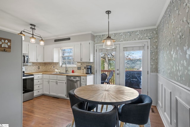 kitchen featuring sink, white cabinets, light hardwood / wood-style flooring, and stainless steel appliances