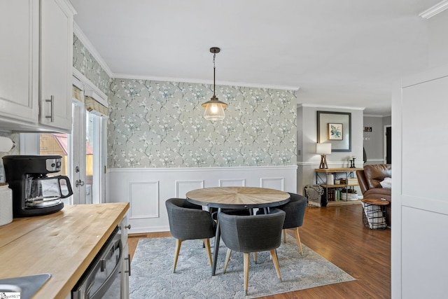 dining room featuring sink, dark hardwood / wood-style floors, and ornamental molding