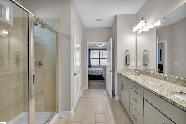 bathroom with a shower with door, tile patterned flooring, and vanity