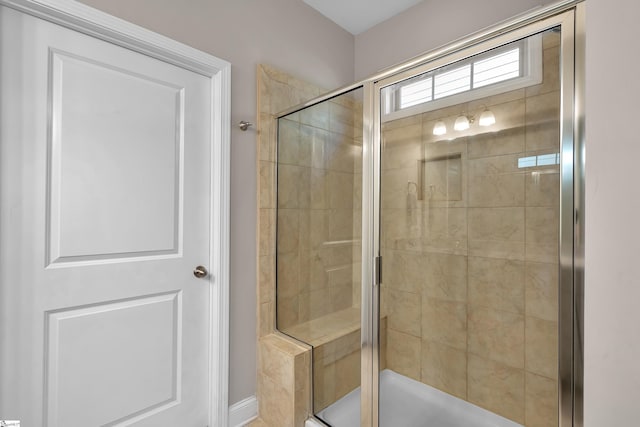 bathroom with a shower with door