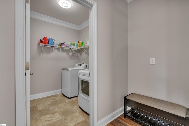 laundry room with washing machine and dryer and ornamental molding