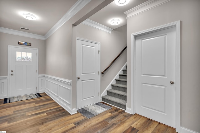 entrance foyer featuring ornamental molding and hardwood / wood-style floors