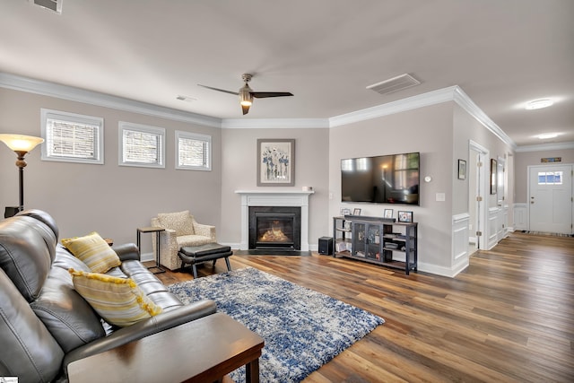 living room with ceiling fan, wood-type flooring, and ornamental molding