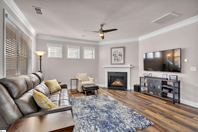 living room featuring hardwood / wood-style flooring, ceiling fan, and ornamental molding