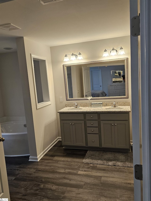 bathroom with hardwood / wood-style floors, a bathtub, and vanity