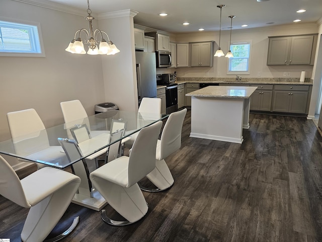 dining area with sink, a chandelier, dark hardwood / wood-style floors, and ornamental molding