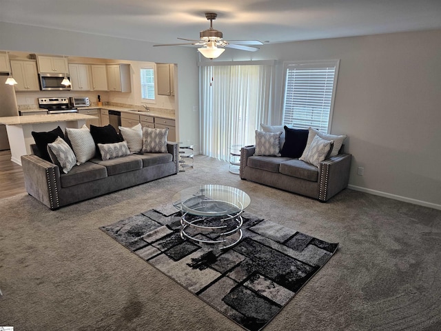 living room with ceiling fan, light colored carpet, and sink