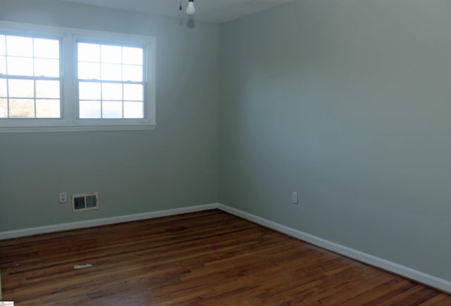 unfurnished room with dark wood-type flooring