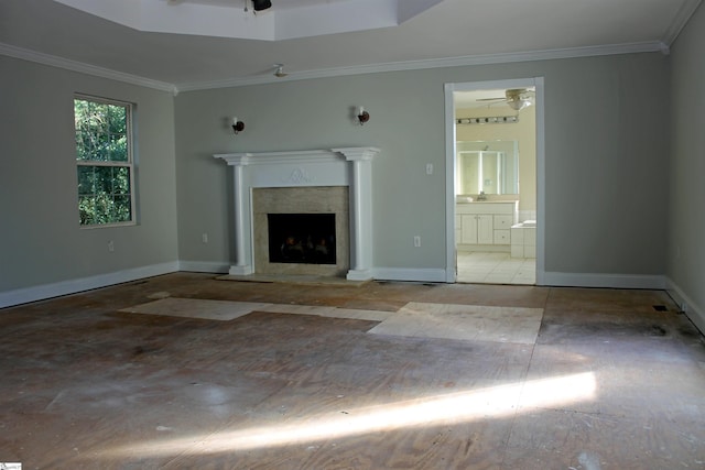 unfurnished living room featuring crown molding, a tray ceiling, ceiling fan, and a high end fireplace