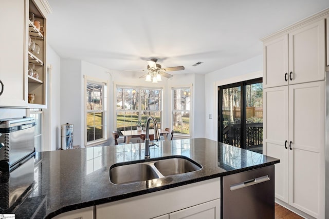 kitchen featuring sink, white cabinets, dishwasher, and dark stone countertops