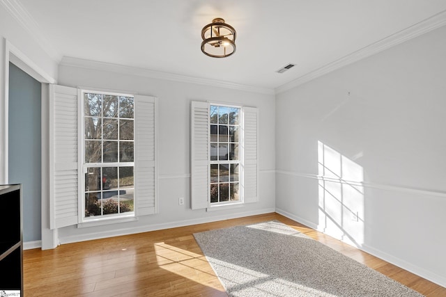 unfurnished dining area featuring hardwood / wood-style flooring, ornamental molding, and plenty of natural light