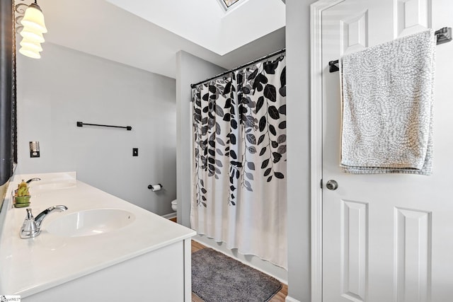 full bathroom featuring toilet, shower / tub combo with curtain, and vanity