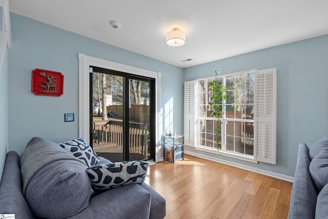 living room with a wealth of natural light and light hardwood / wood-style flooring