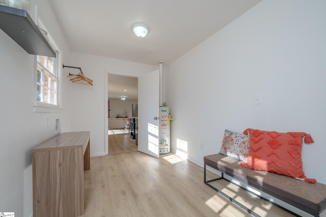 corridor with water heater and light hardwood / wood-style flooring