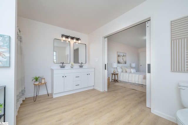 bathroom featuring wood-type flooring, toilet, and vanity