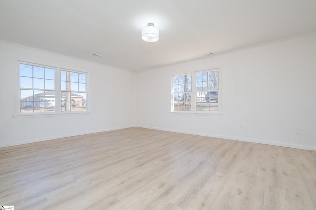 spare room with crown molding and light hardwood / wood-style flooring