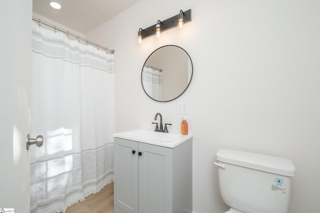 bathroom with vanity, toilet, and hardwood / wood-style floors