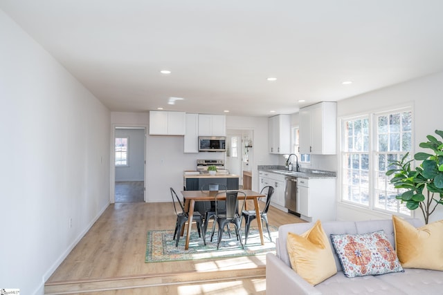 dining area with light wood-type flooring and sink