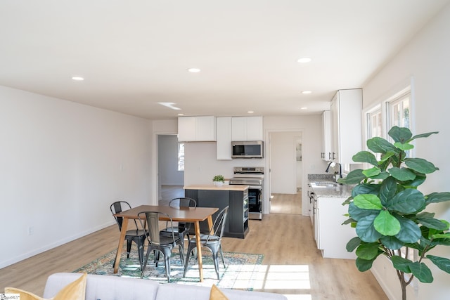 dining space featuring sink and light wood-type flooring