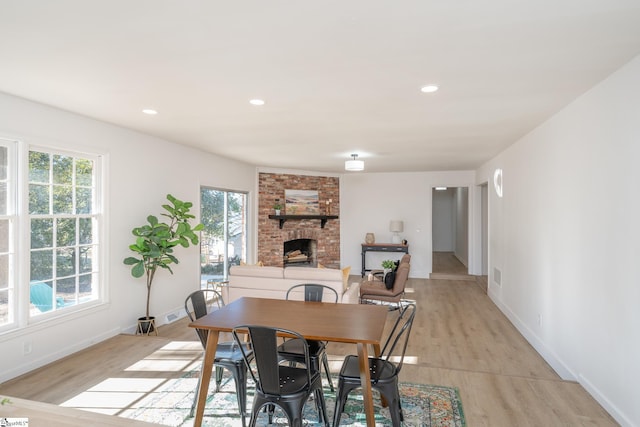 dining area with a fireplace and light hardwood / wood-style floors