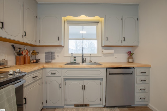 kitchen featuring sink, tasteful backsplash, white cabinetry, and stainless steel appliances