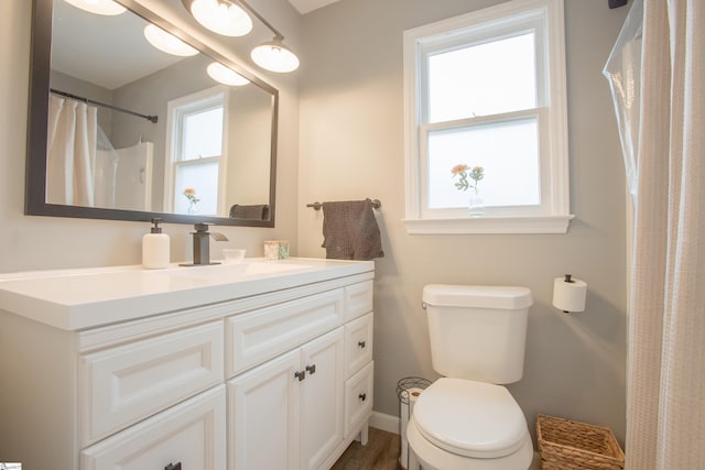 bathroom with hardwood / wood-style floors, toilet, vanity, and a shower with shower curtain