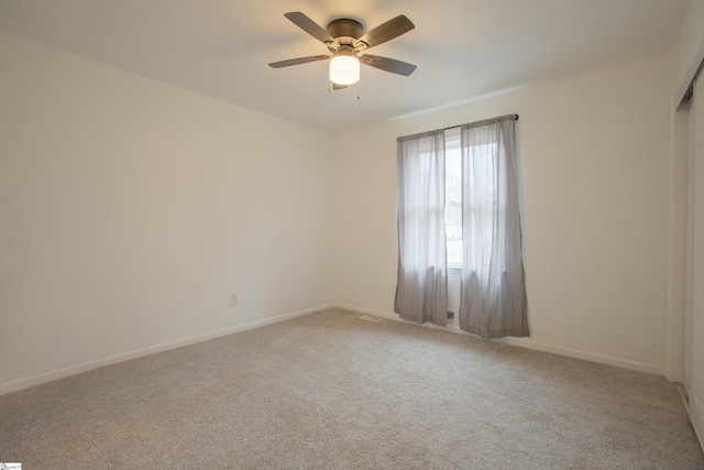 carpeted empty room featuring ceiling fan