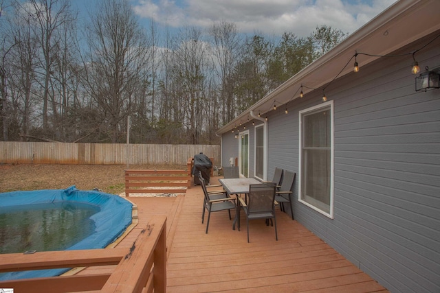 deck featuring a covered pool and a grill