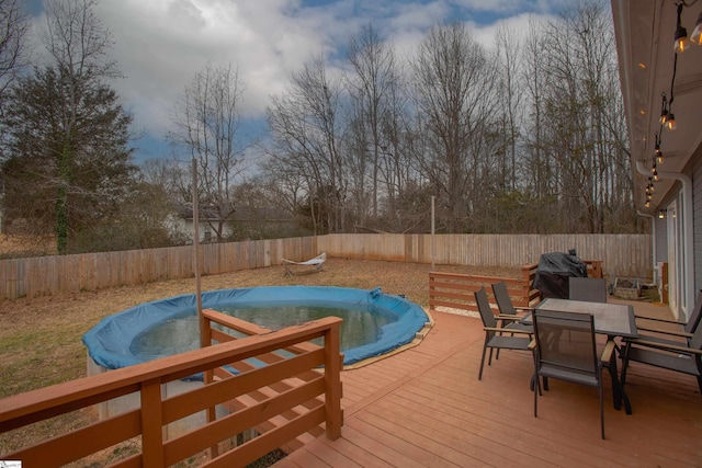 wooden deck with a covered pool and a grill