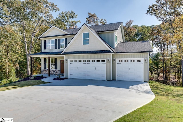 craftsman-style home with a garage, covered porch, and a front lawn