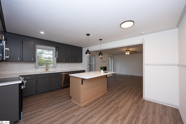 kitchen with hanging light fixtures, appliances with stainless steel finishes, sink, a center island, and a breakfast bar area