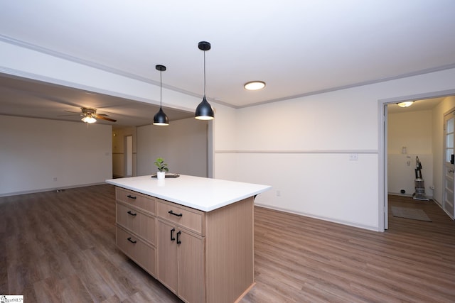 kitchen featuring hardwood / wood-style flooring, decorative light fixtures, a kitchen island, ceiling fan, and light brown cabinets