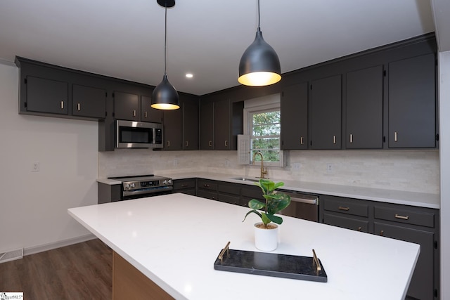 kitchen featuring sink, a kitchen island, hanging light fixtures, and stainless steel appliances