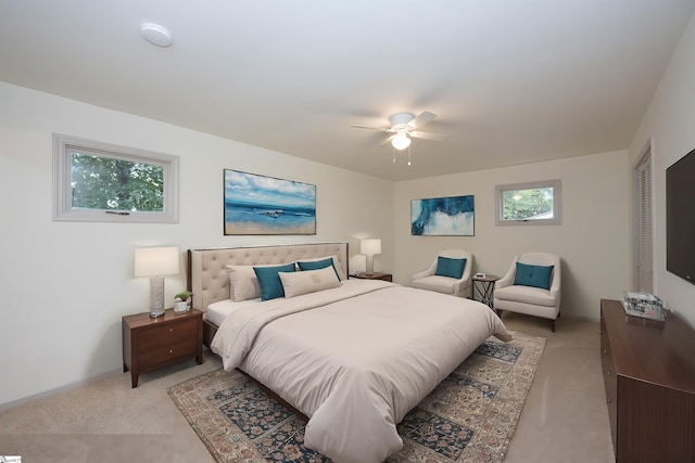 bedroom with ceiling fan, multiple windows, a closet, and light carpet