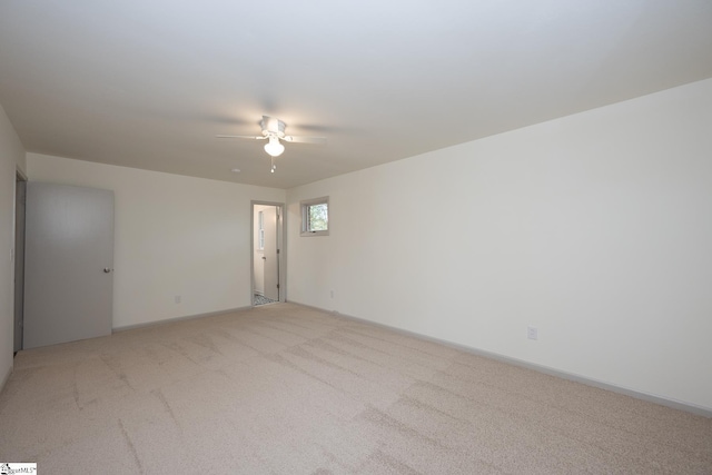 unfurnished room with ceiling fan and light carpet