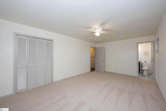 unfurnished bedroom with a closet, ceiling fan, ensuite bathroom, and light colored carpet