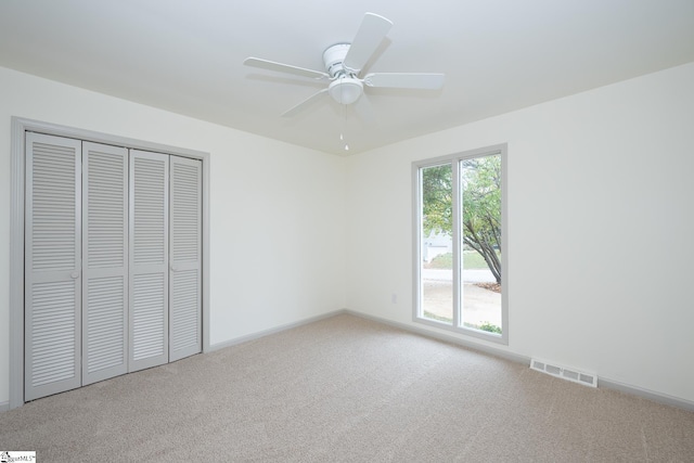 unfurnished bedroom with ceiling fan, a closet, and carpet floors