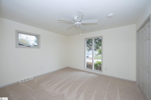 unfurnished bedroom with light carpet, a closet, and ceiling fan