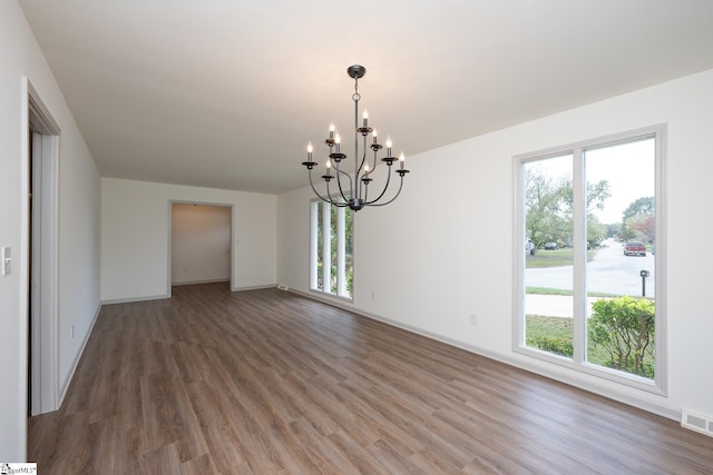 unfurnished dining area with dark hardwood / wood-style flooring and a chandelier