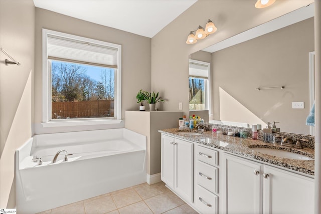 bathroom featuring a bathing tub, tile patterned floors, and vanity