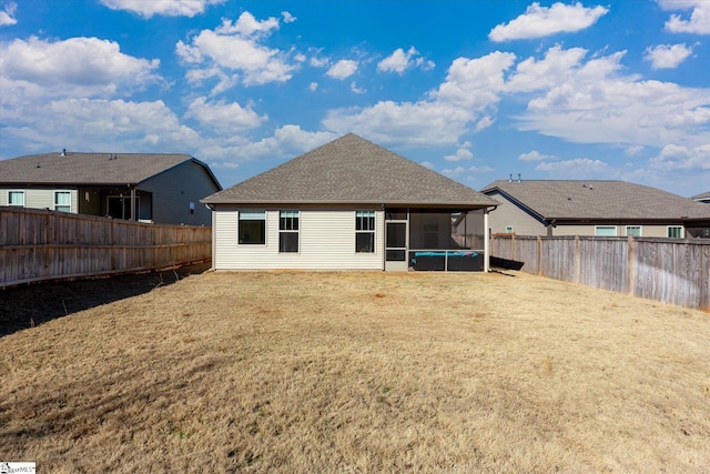 back of property with a sunroom and a lawn