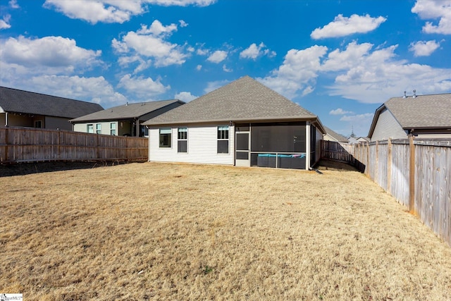 rear view of property with a sunroom and a lawn