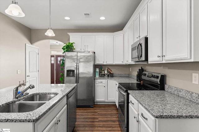 kitchen featuring white cabinets, decorative light fixtures, stainless steel appliances, sink, and light stone counters