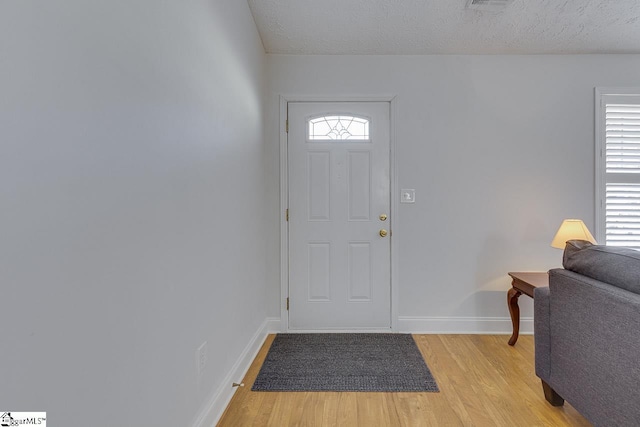 entrance foyer with light hardwood / wood-style floors and a textured ceiling