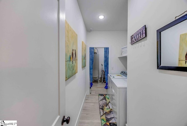 hallway with light wood-type flooring and washer and clothes dryer